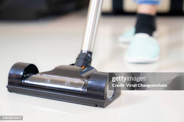 part of woman vacuuming living room at home - vacuum cleaner fotografías e imágenes de stock