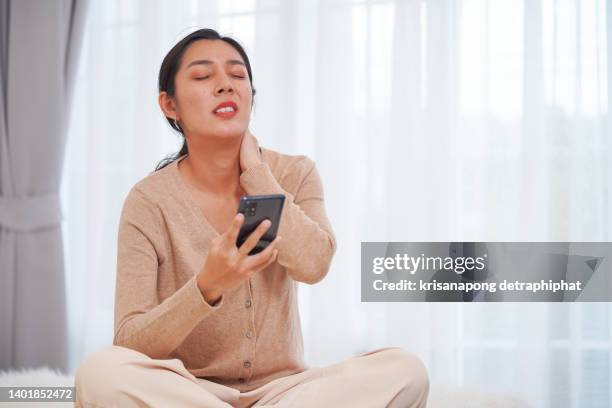 beautiful woman using smart phone with neck pain,stressed woman - frustrated on phone stock-fotos und bilder