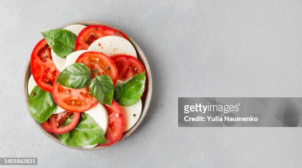 caprese salad with tomato, mozzarella and basil leaves. - caprese imagens e fotografias de stock