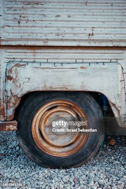 front view of the wheel of a vintage van at the junkyard. - rouillé photos et images de collection