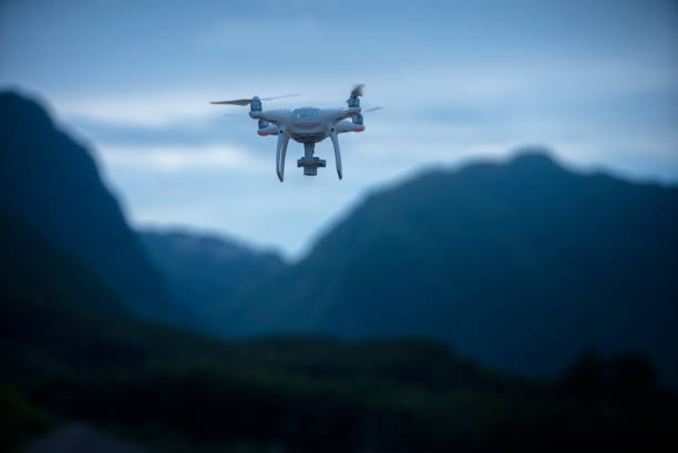 agricultural drone flying over the trees plantation with a mountain background