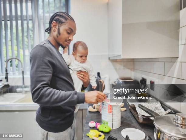 young father preparing baby milk formula in kitchen - milk powder stock pictures, royalty-free photos & images