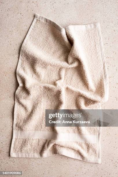 close-up of folded beige bath towel on concrete background, top view - dish towel stock pictures, royalty-free photos & images