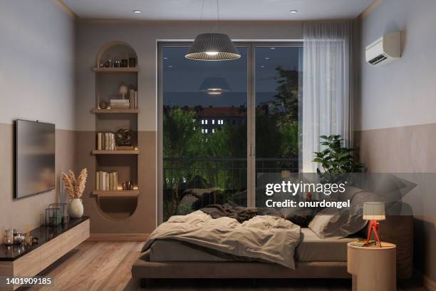 moderno interno della camera da letto di notte con letto matrimoniale disordinato, aria condizionata e televisore - bedroom window foto e immagini stock
