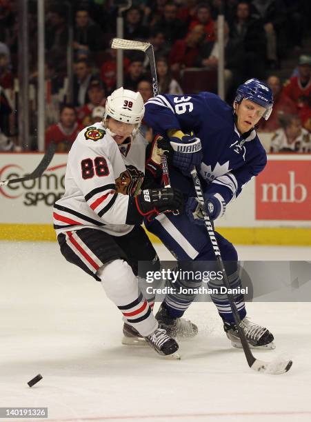 Patrick Kane of the Chicago Blackhawks battles for position with Carl Gunnarsson of the Toronto Maple Leafs at the United Center on February 29, 2012...