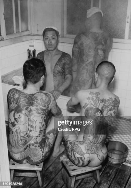 Four men covered in Japanese traditional tattoos in a bathhouse, Japan, 1955.