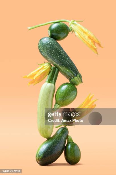 balance mit grünem zucchinigemüse auf beigem hintergrund. gesundes essen und life balance konzept. - cabbage flower stock-fotos und bilder