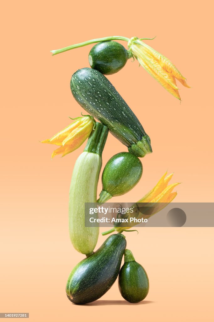 Balance with green zucchini vegetables on beige background. Healthy food and life balance concept.