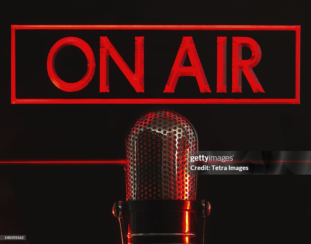 Vintage microphone and red on air neon, studio shot