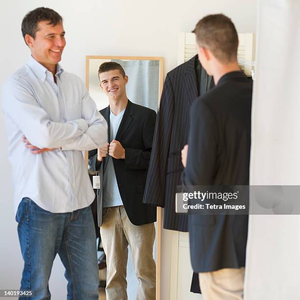 usa, new jersey, jersey city, father with teenage (16-17) son buying suit - teenager boy shopping stock pictures, royalty-free photos & images