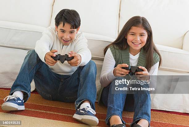 usa, new jersey, jersey city, brother (12-13) and sister (10-11) playing video games - mädchen 10 12 stock-fotos und bilder