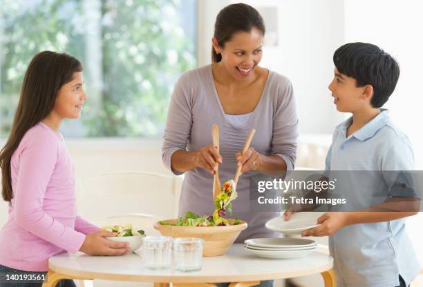 usa, new jersey, jersey city, mother with son (12-13) and daughter (10-11) preparing salad - jersey city stock pictures, royalty-free photos & images