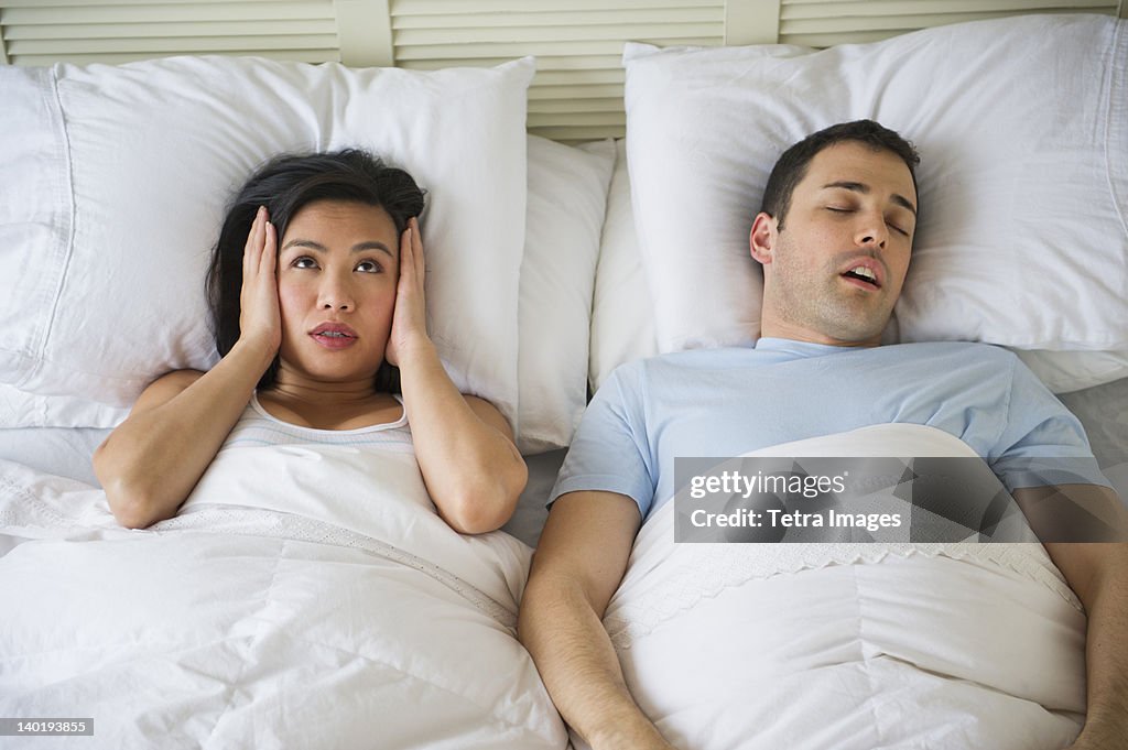 USA, New Jersey, Jersey City, Couple in bed, man snoring