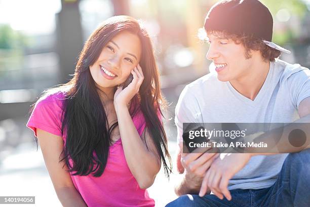 usa, washington, seattle, young couple sitting together playing with their mobile phones -  "suprijono suharjoto" or "take a pix media" stock pictures, royalty-free photos & images