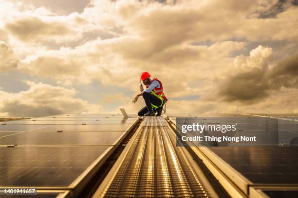 african american engineering are about to checking solar panels. electrical and instrument technician use laptop to maintenance electric solution - pep stockfoto's en -beelden