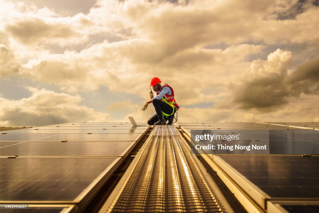 African american engineering are about to checking solar panels. Electrical and instrument technician use laptop to maintenance electric solution