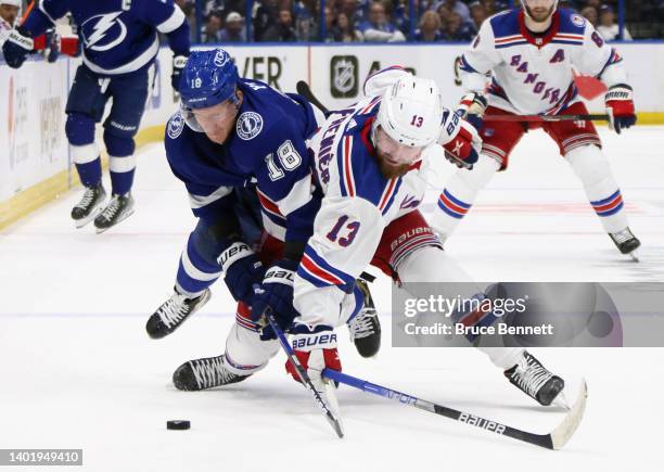 Ondrej Palat of the Tampa Bay Lightning and Alexis Lafreniere of the New York Rangers battle for the puck in Game Four of the Eastern Conference...