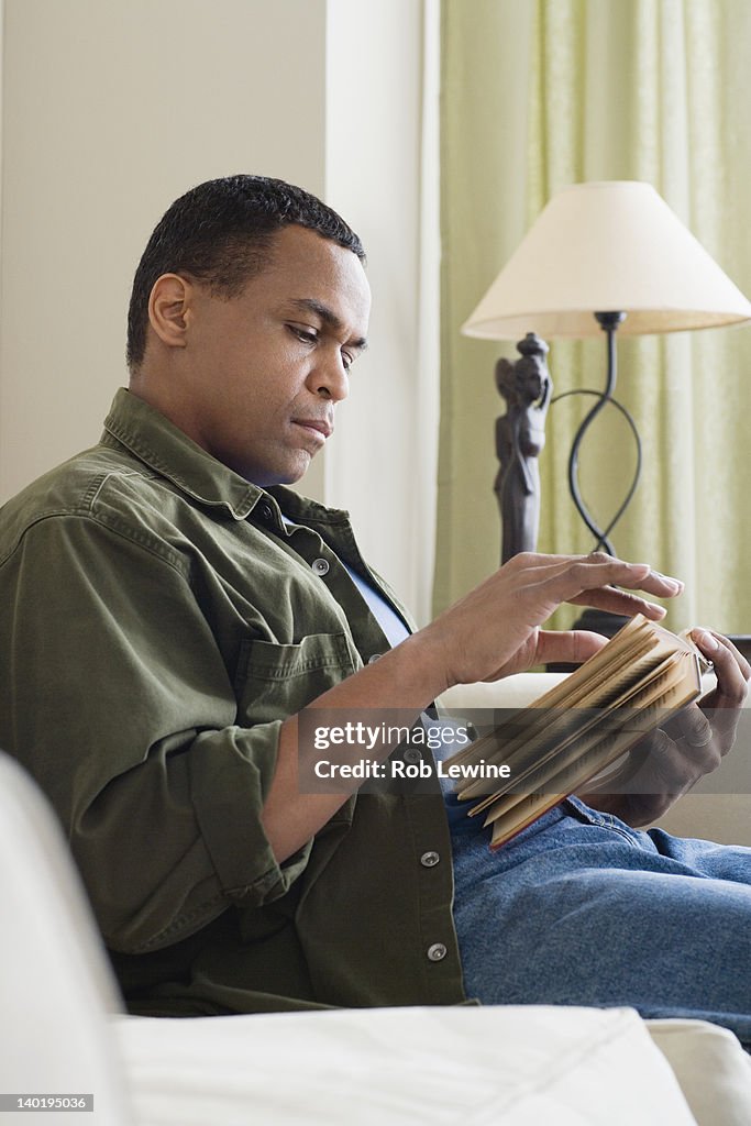 USA, California, Los Angeles, Man reading book at home