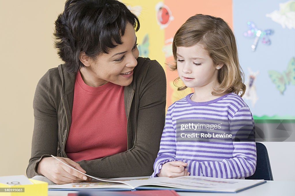 USA, California, Los Angeles, Teacher helping girl (6-7) in reading