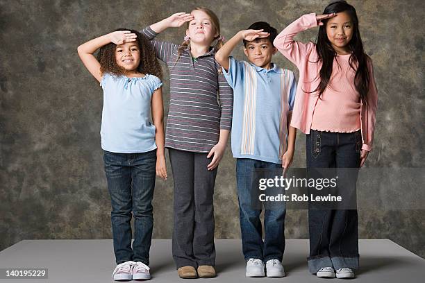 children (6-7, 8-9) saluting, studio shot - child saluting stock-fotos und bilder