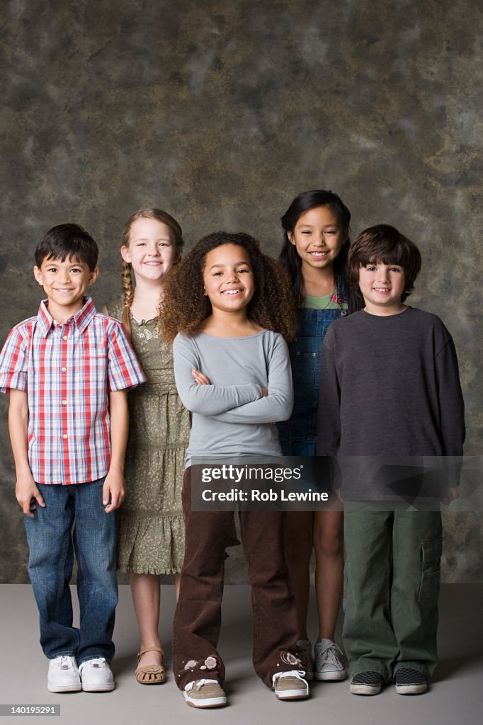 Children (6-7, 8-9) posing together, studio shot
