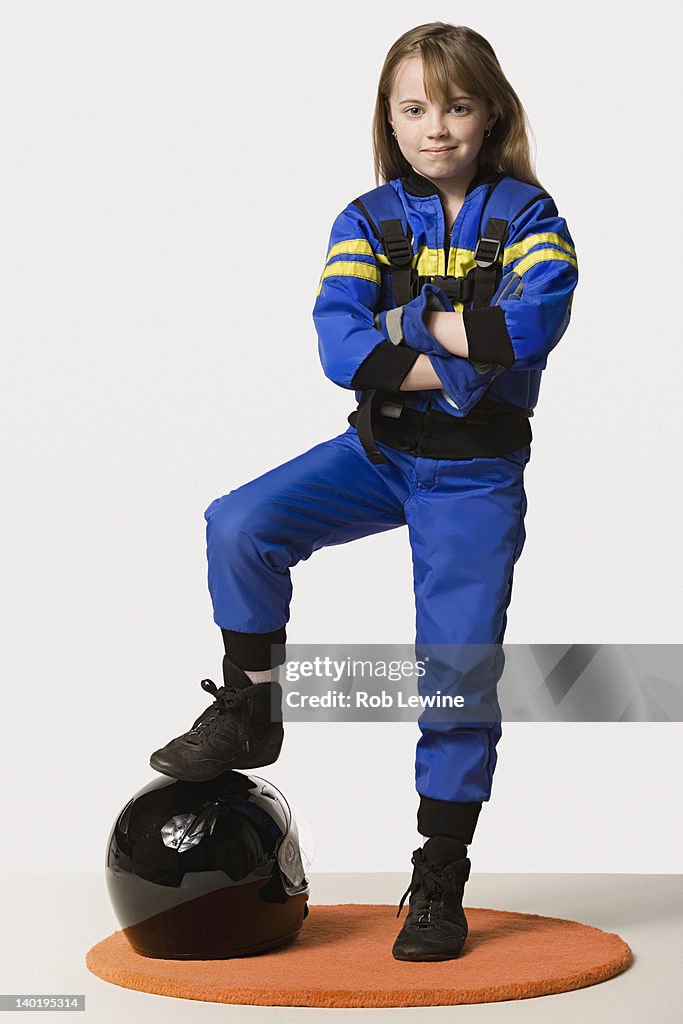 Portrait of girl (8-9) dressed as racing driver, studio shot