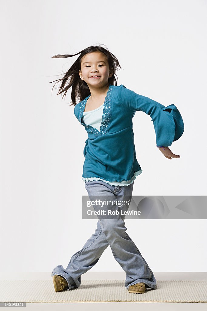 Smiling girl (8-9) dancing, studio shot