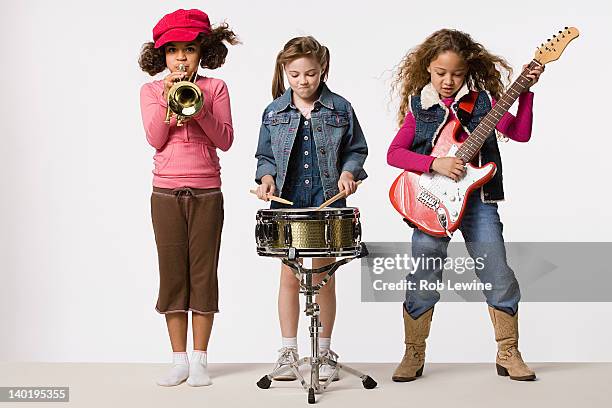 three girls (8-9) playing instruments together, studio shot - drum percussion instrument 個照片及圖片檔