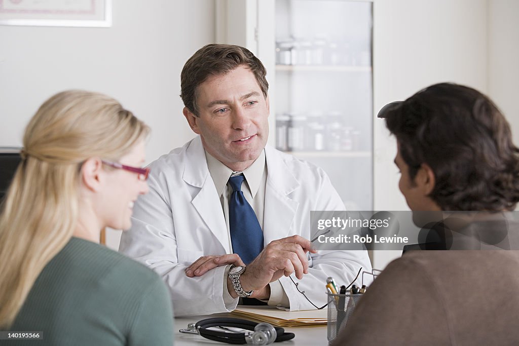 USA, California, Los Angeles, Male doctor talking to patients in his office