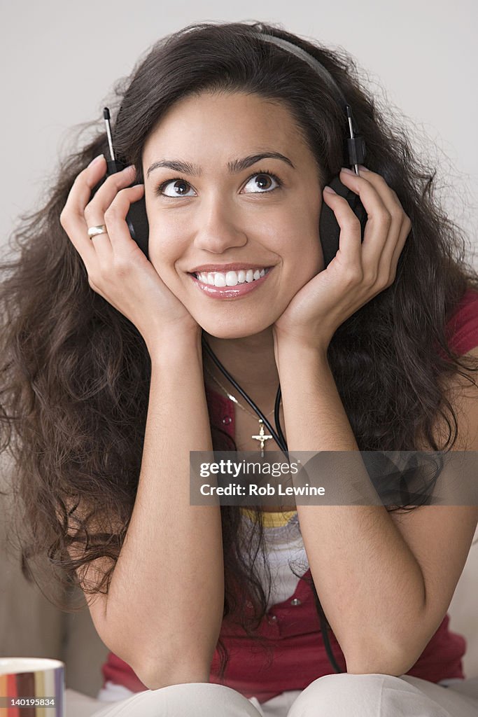 USA, California, Los Angeles, Young woman listening to music and smiling