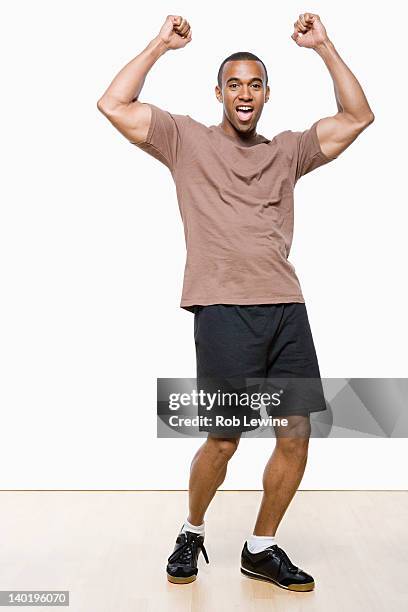 studio portrait of young man cheering - man cheering stock pictures, royalty-free photos & images