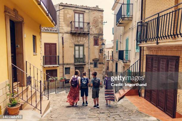 mother and teenagers walking in the streets of italian town - sicily italy stock pictures, royalty-free photos & images