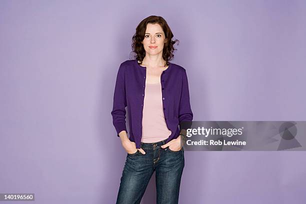 portrait of smiling woman on purple background, studio shot - encuadre de tres cuartos fotografías e imágenes de stock