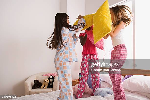 usa, california, los angeles, three girls (10-11) having pillow fight at slumber party - lucha con almohada fotografías e imágenes de stock