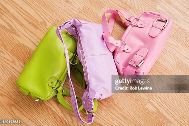 usa, california, los angeles, close up of three colorful purses on parquet floor - bunte handtasche stock-fotos und bilder