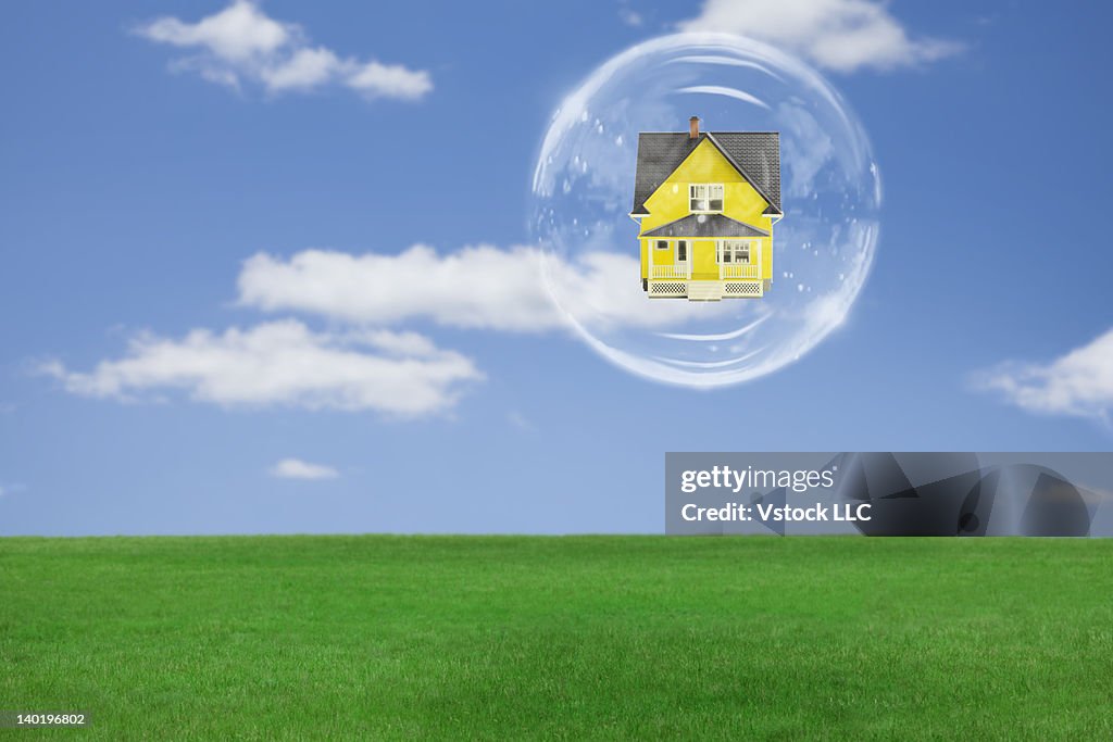 Model house in soap bubble above grass