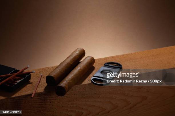 two cigars and matches on the wooden beam - cigar texture stock pictures, royalty-free photos & images