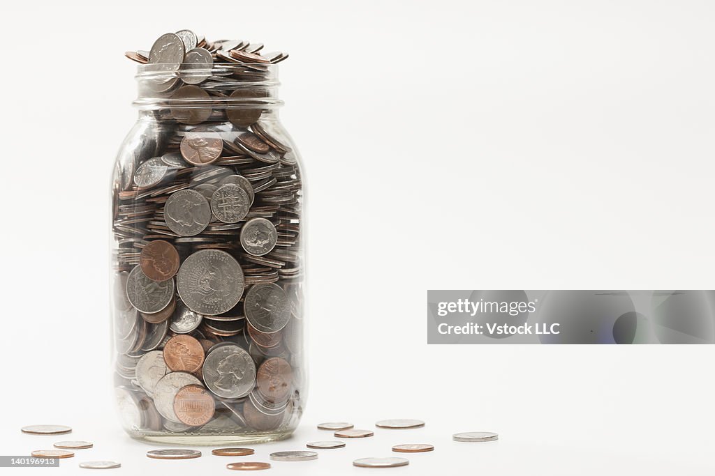 Studio shot of jar full of coins
