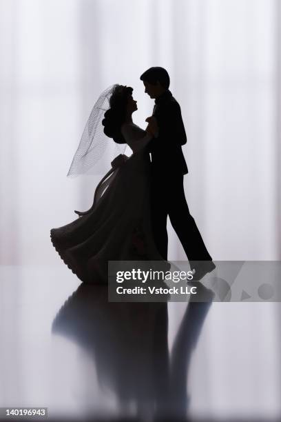 studio shot of silhouettes of bride and groom figurines dancing - wedding cake figurine stock pictures, royalty-free photos & images
