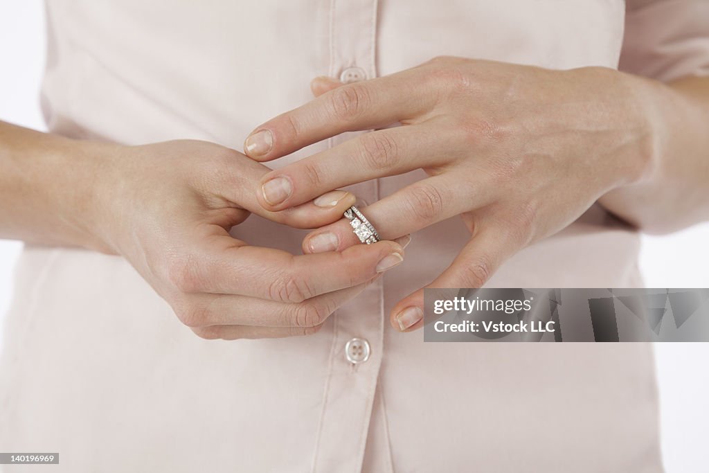 Close-up of woman removing wedding ring from finger