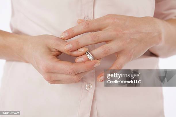 close-up of woman removing wedding ring from finger - taking off wedding ring stock pictures, royalty-free photos & images