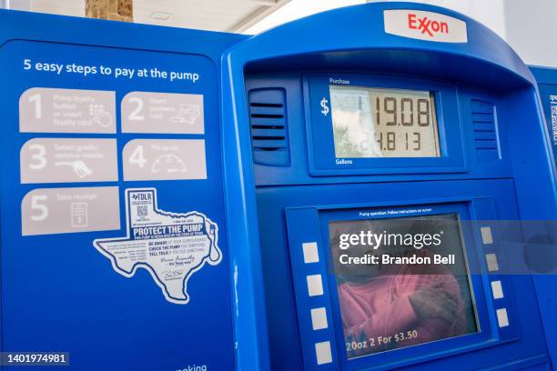 Customer is seen in a reflection looking at the rising cost while pumping gas at an Exxon Mobil gas station on June 09, 2022 in Houston, Texas. Gas...
