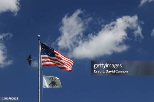 The Curtis Cup flag flies beneath the American flag beside the 18th green during final practice ahead of The Curtis Cup at Merion Golf Club on June...