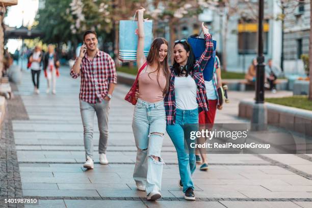 young people shopping in the mall in front of a fashion shop - sports equipment store stock pictures, royalty-free photos & images