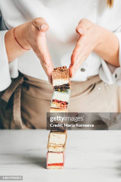 young woman chef shows various of cake. - chef patissier stock pictures, royalty-free photos & images