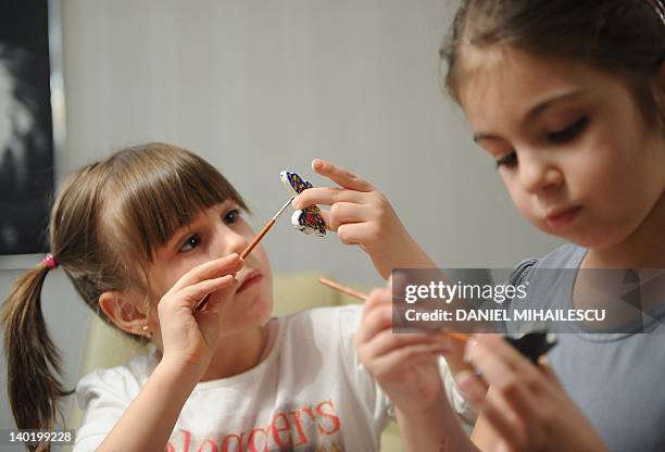 Children paint butterflies during a "martisor" workshop organized by a company for the children of employees in Bucharest February 22, 2012. Every...