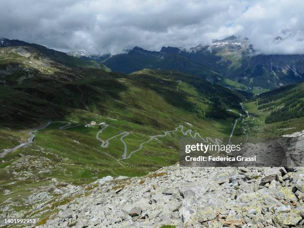high-angle view of splügenpass (passo spluga) seen from via spluga trail - snow border stock pictures, royalty-free photos & images