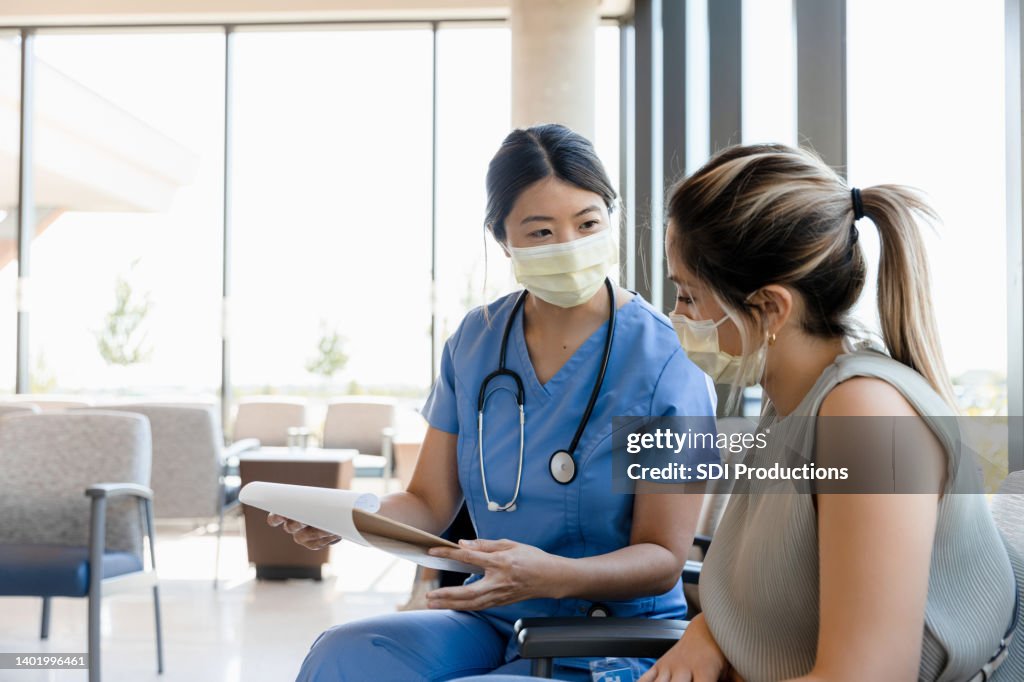 Female nurse asks young woman questions for record