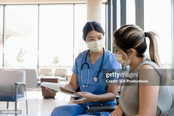 enfermeira faz perguntas para jovem para registro - female surgeon mask - fotografias e filmes do acervo