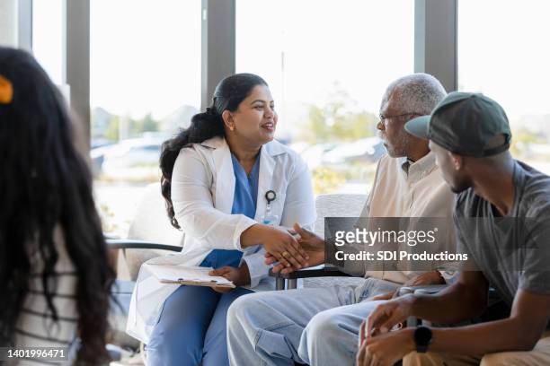 female doctor greets senior patient with handshake - outpatient care bildbanksfoton och bilder